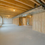 DIY Basement Insulation: How to Insulate Your Unfinished Basement A bright unfinished basement with foam board insulation, vapor barriers, and exposed wood joists showing proper DIY basement insulation setup.