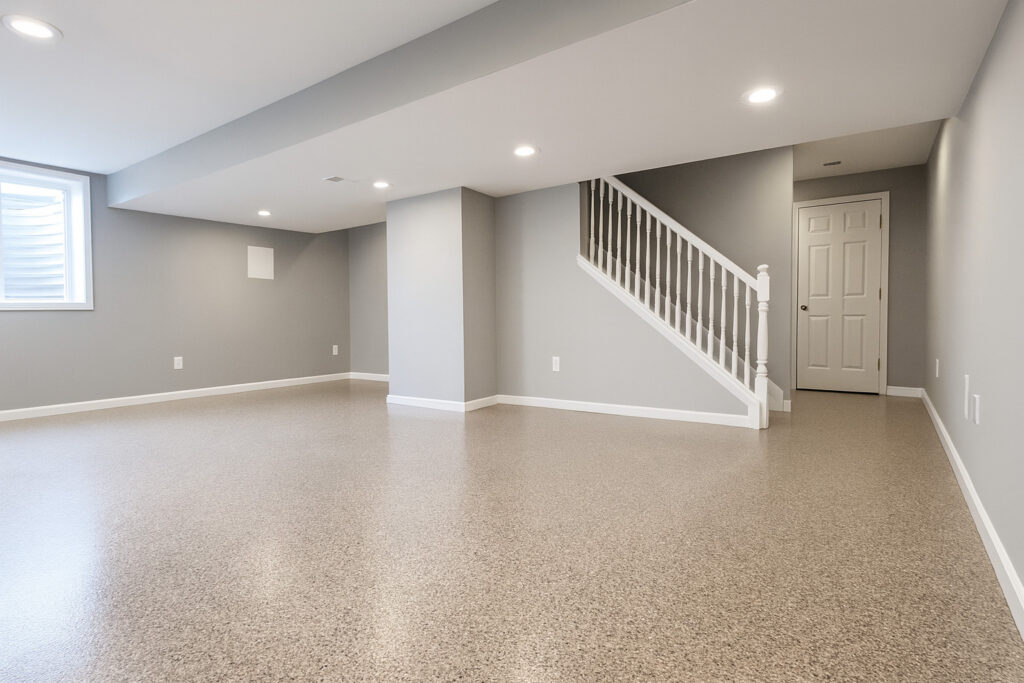 DIY Basement Floor Epoxy Coating for Concrete Floors Finished basement with glossy epoxy floor coating and gray walls under recessed lighting