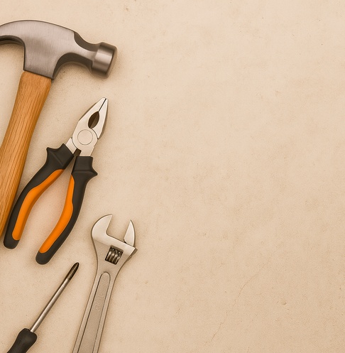 Home Repair Tools on Beige Background Hammer, pliers, wrench, and screwdriver arranged on a beige surface