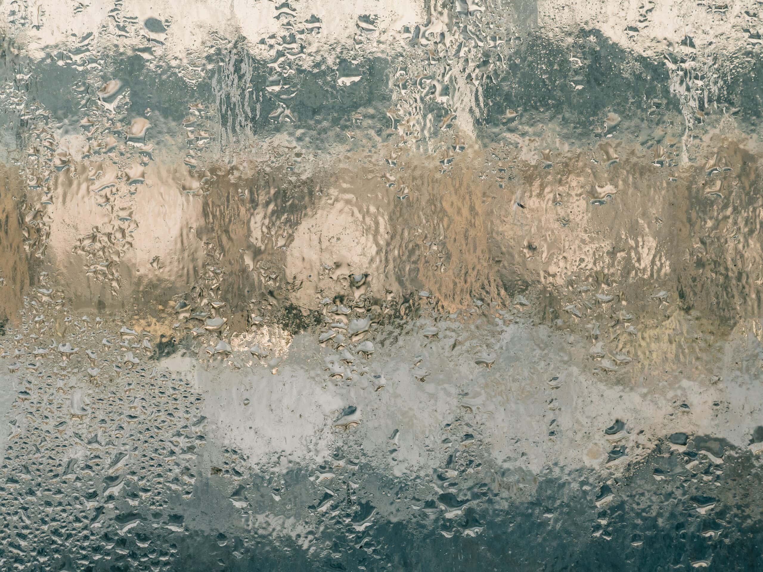 Condensation on a cold basement window showing high humidity and moisture buildup that signals poor waterproofing or ventilation