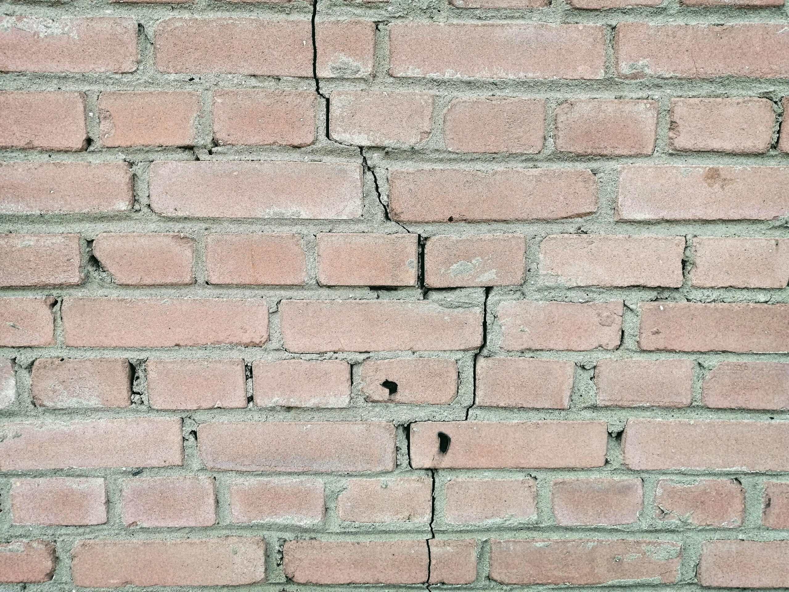Cracked brick foundation wall repair for basement stability and moisture prevention.
