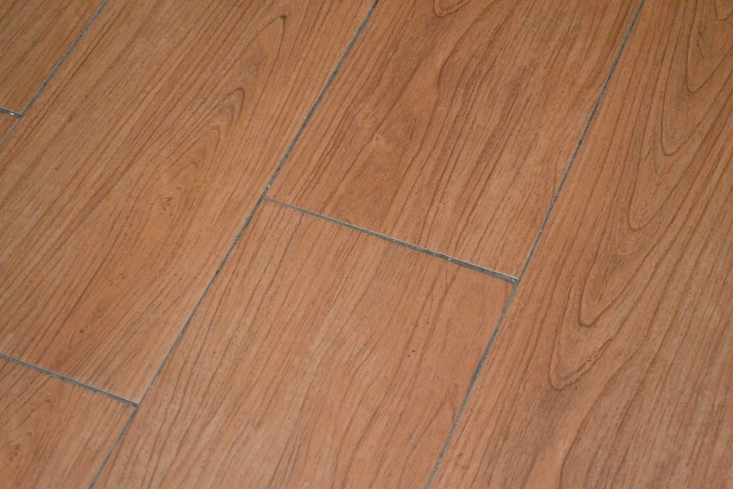 Close-up view of engineered wood plank flooring with metal furniture legs on top