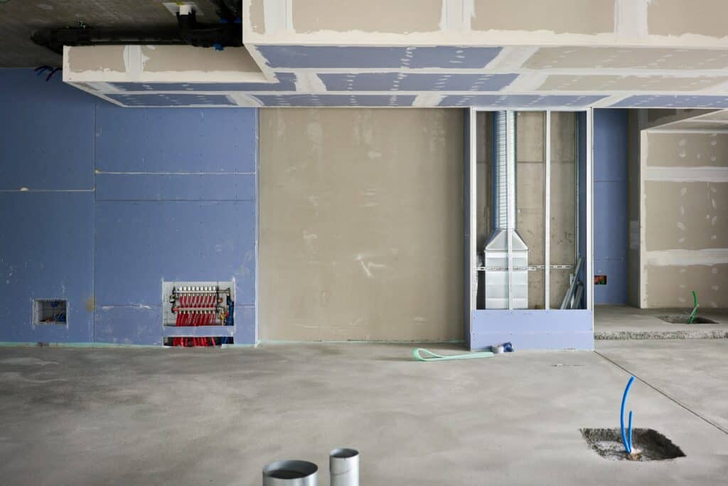 Basement wall with insulation, plasterboard, and mechanical systems during installation