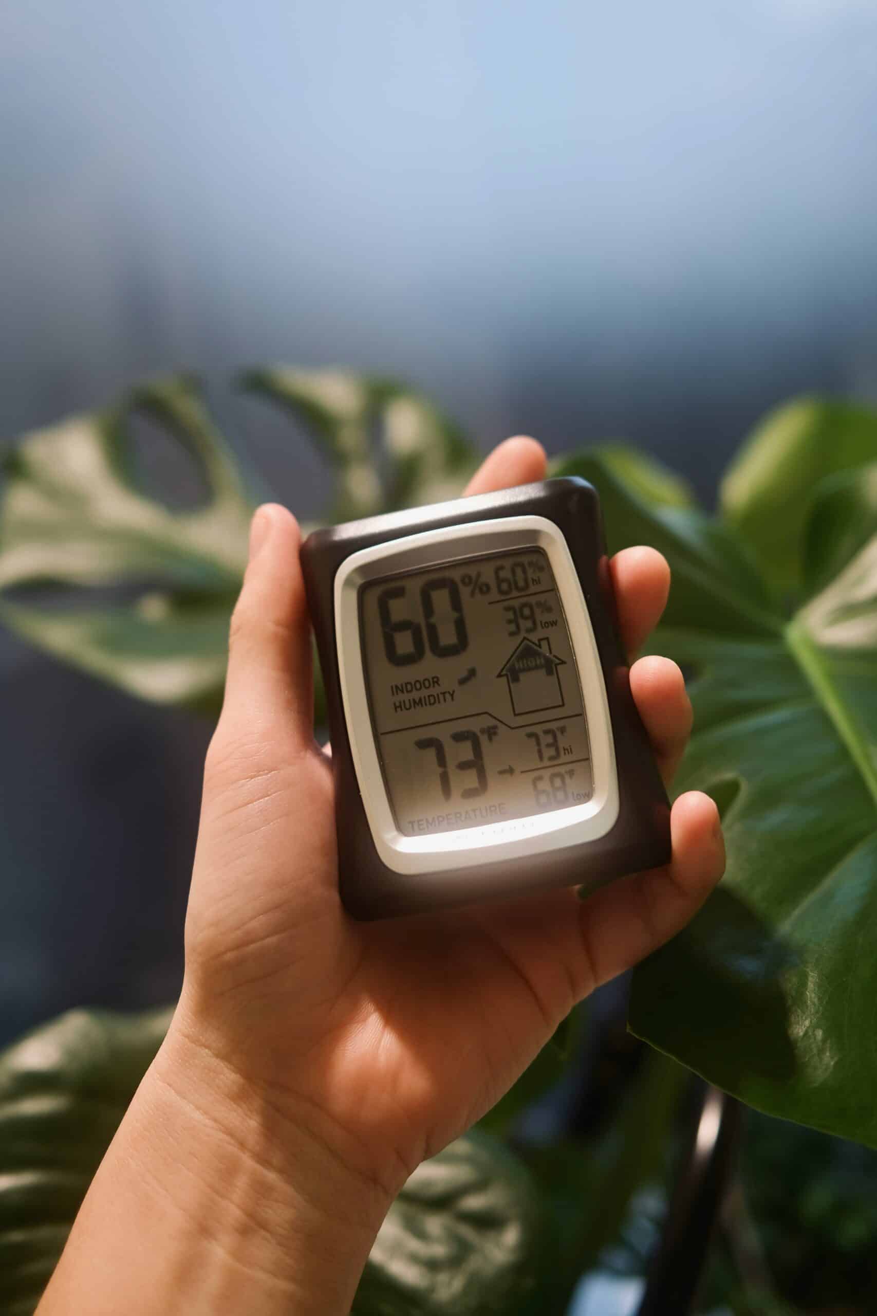 Handheld digital hygrometer showing 60 percent indoor humidity, which is too high for most basements and can promote mold and dust mites